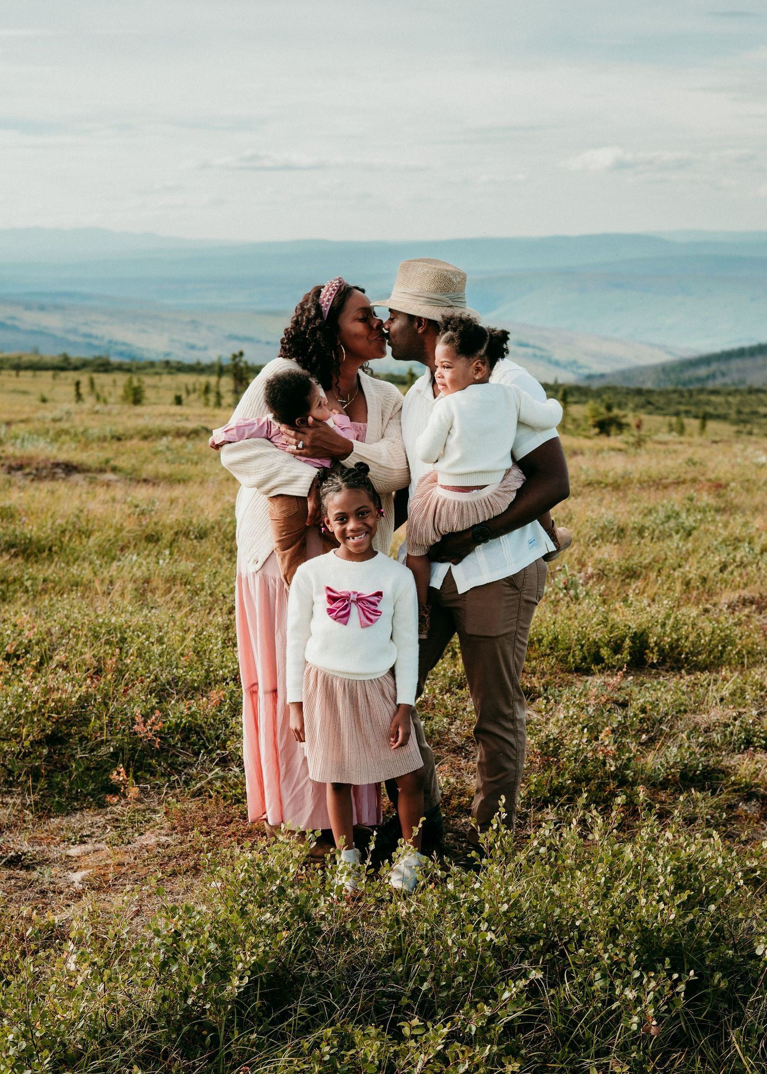 Family standing together in a grassy field during an outdoor family photography session