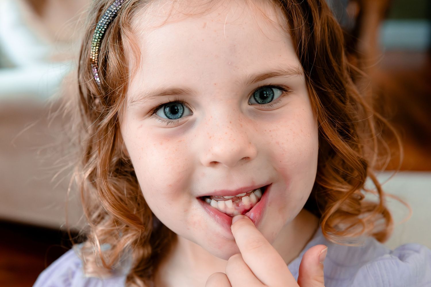 Child smiling with missing front teeth during back-to-school portrait session in Western North Carolina
