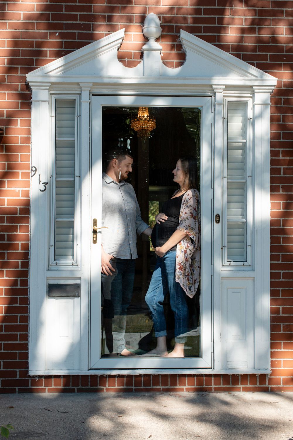 Outside, looking in exterior shot of couple during their in-home maternity session in Flint, Michigan