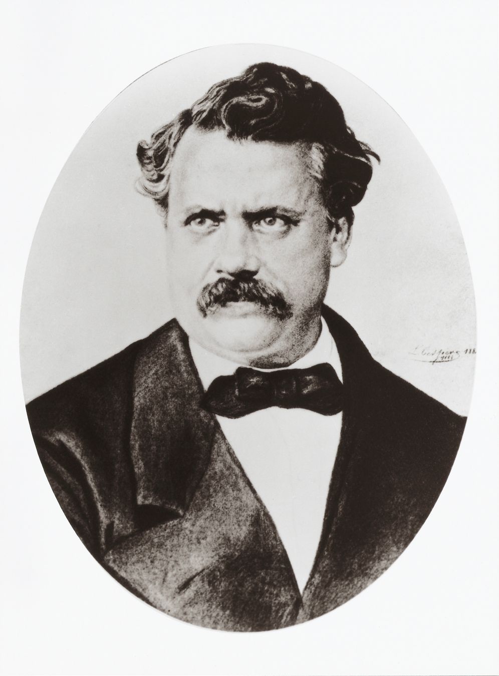 Vintage oval portrait of a 19th-century man with dark curly hair and mustache wearing a black bow tie and jacket.
