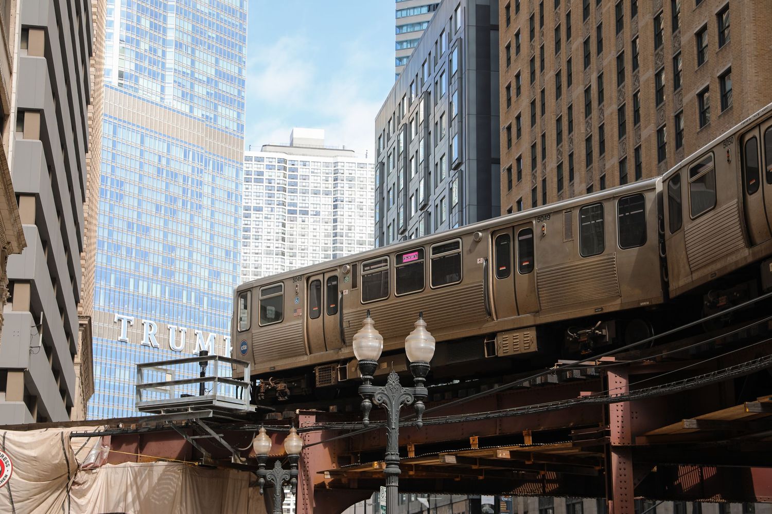 Chicago elevated train on the L rail system passing between downtown skyscrapers near Trump Tower.
