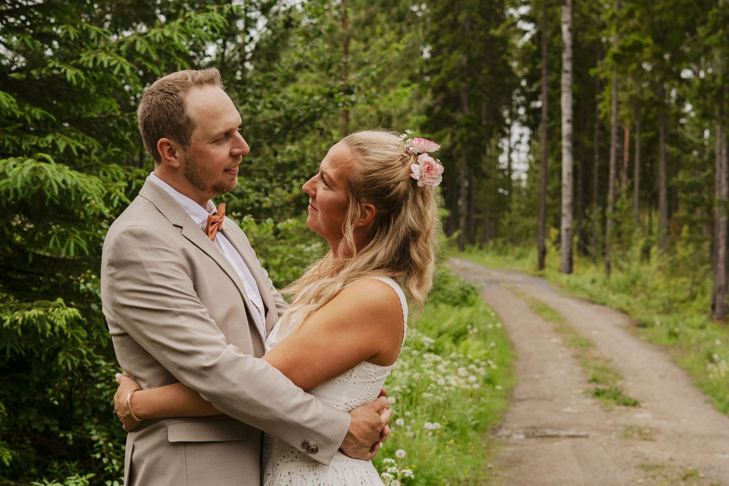 Brudpar ser kärleksfullt på varandra under sin bröllopsfotografering i Ockelbo, Sandviken