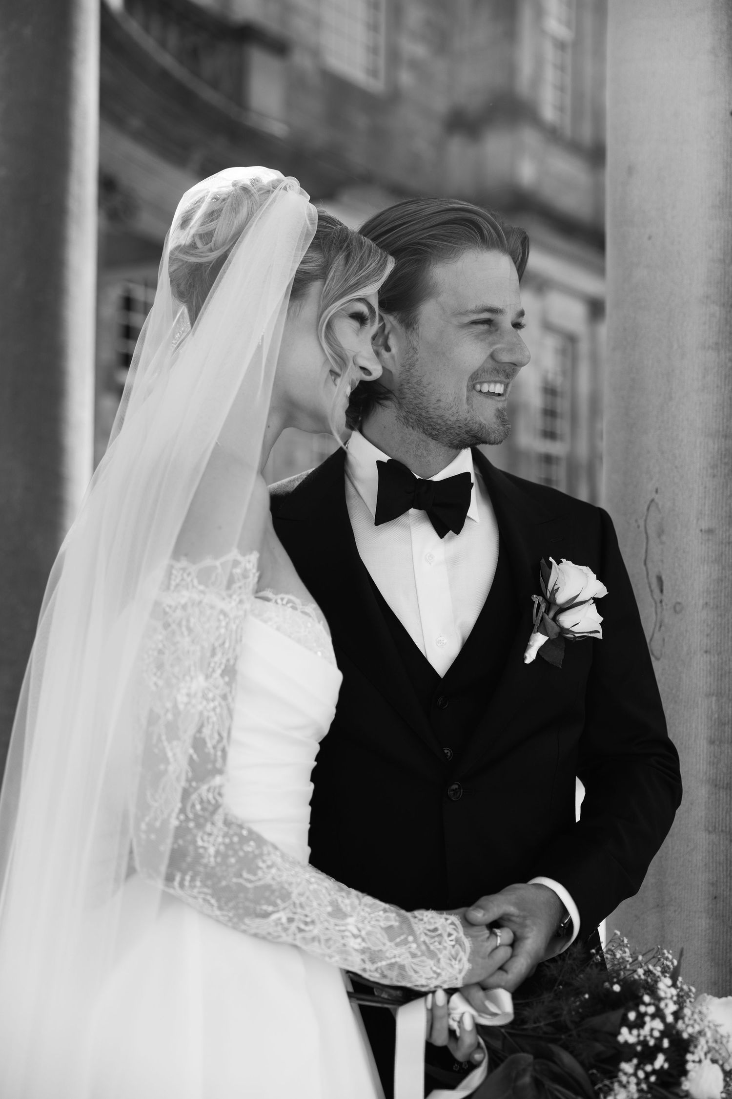Intimate black and white wedding kiss captured in indoor reception venue.