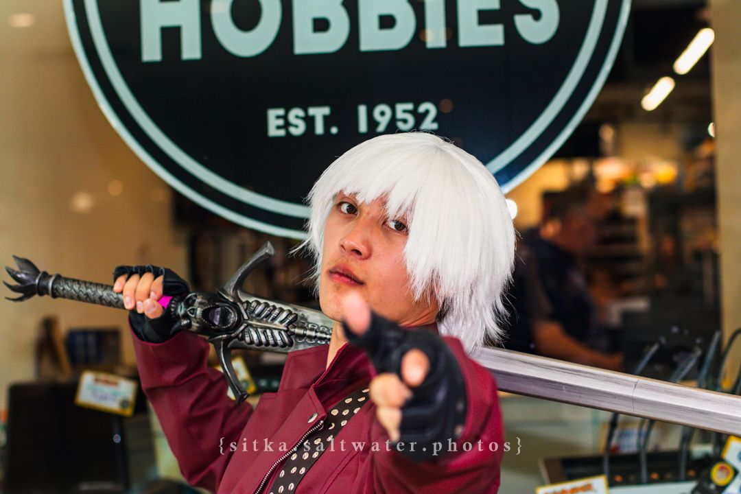 Person cosplaying with white wig and sword prop outside Hobbies store established 1952.