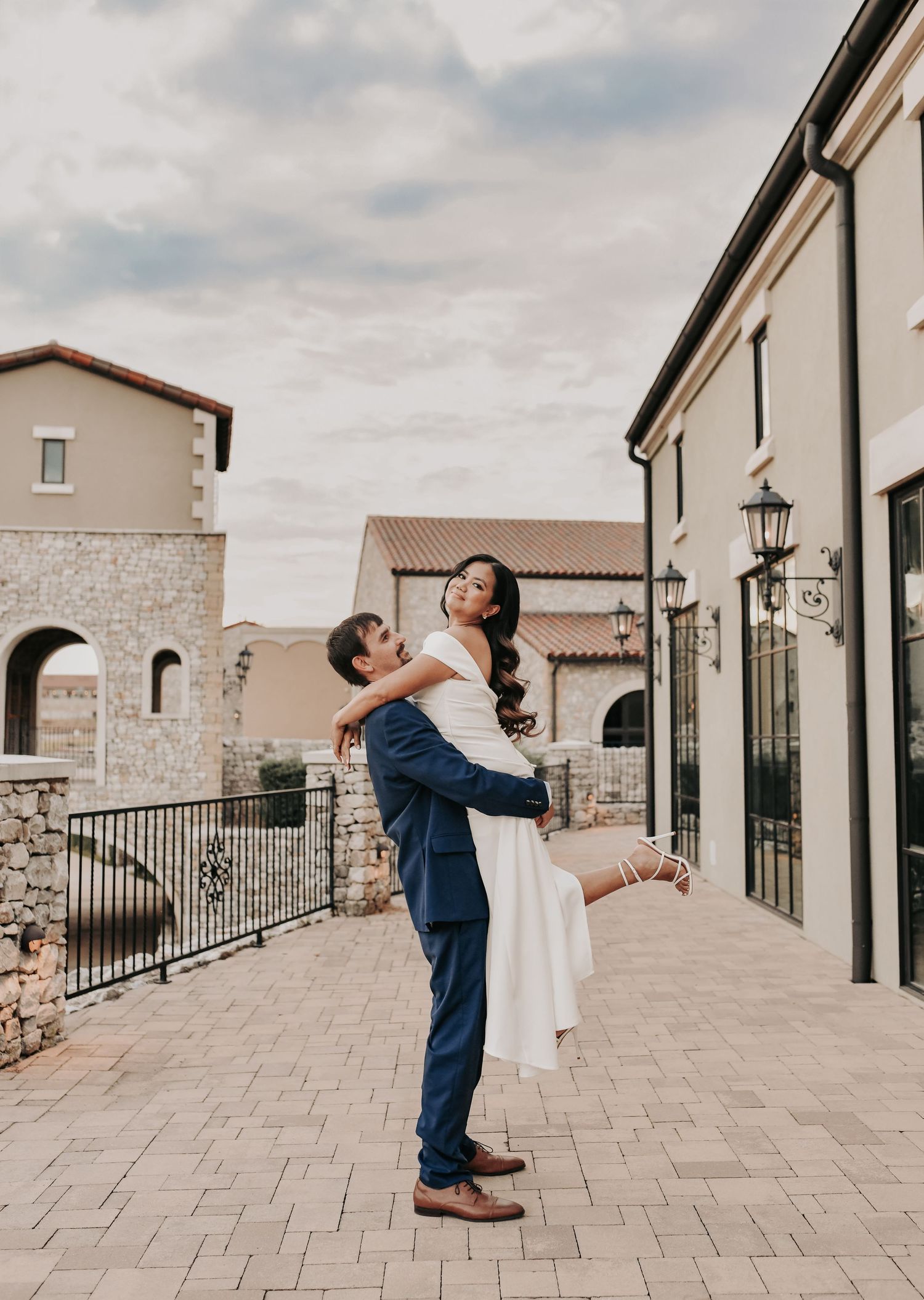 Modern engagement portrait featuring the stone architecture and waterfront at Chapel at Palacios