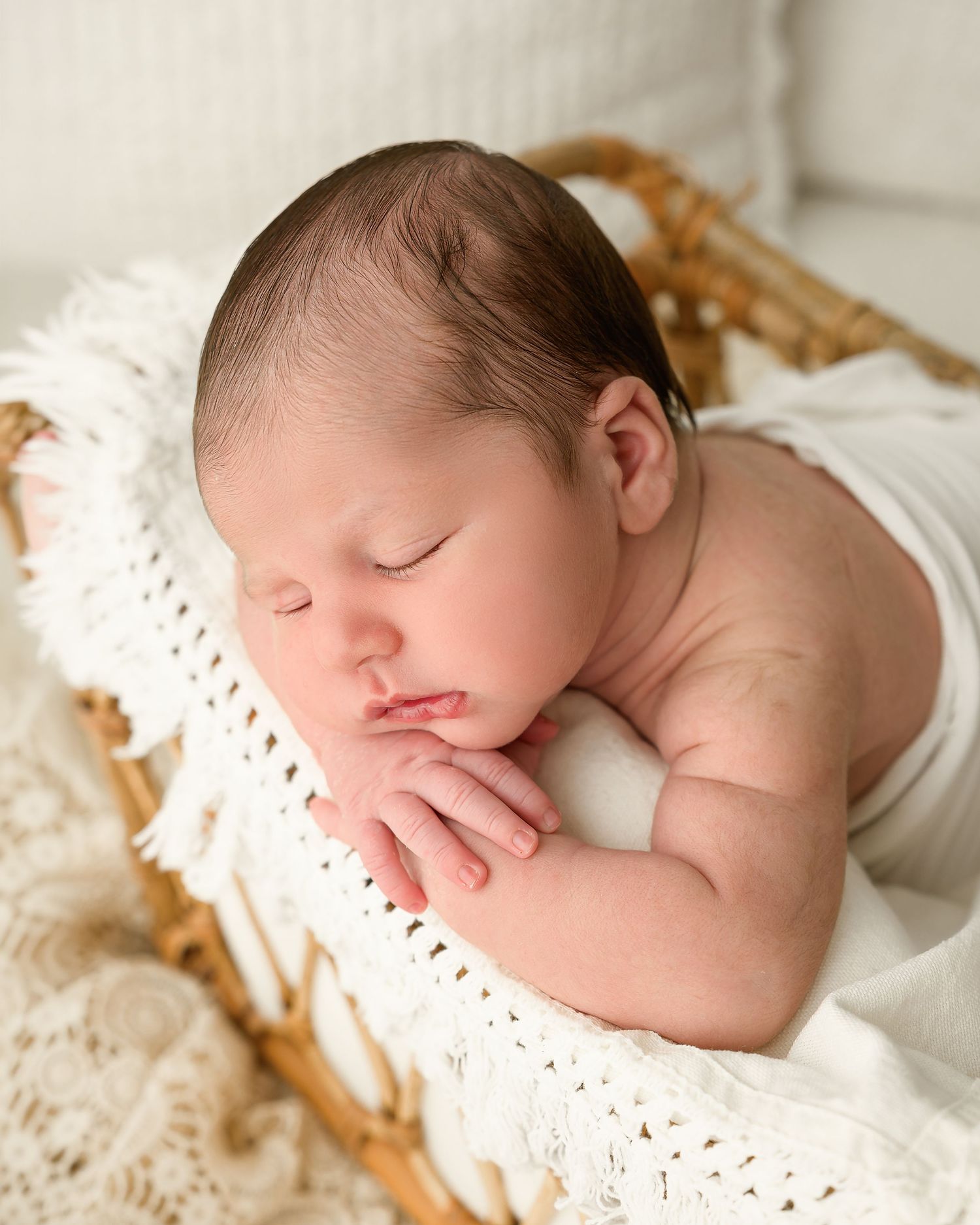 Sleeping newborn baby posed in a natural cream setup during a studio newborn photography session in Zephyrhills, Florida
