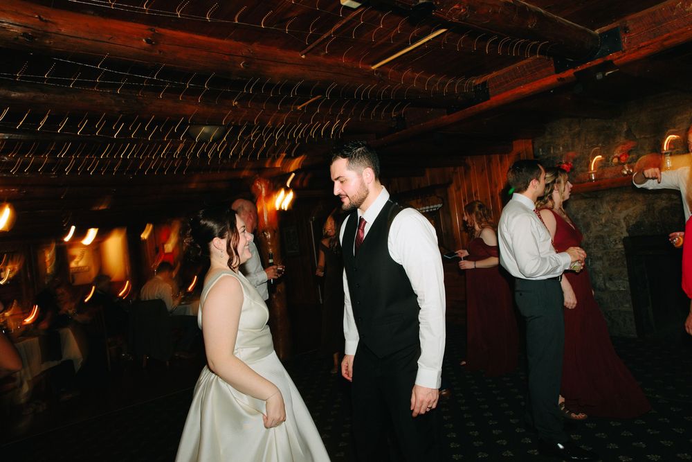 Bride and groom share a joyful first dance at their rustic wedding reception venue.