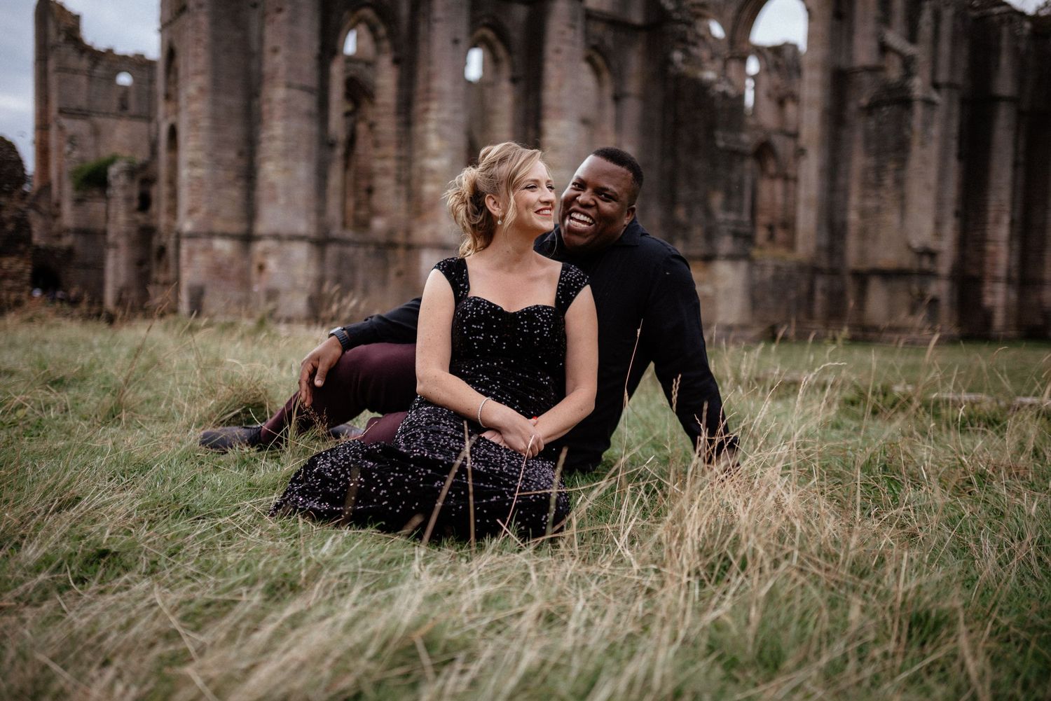 Romantic portraits captured near ancient stone ruins on an overcast day.