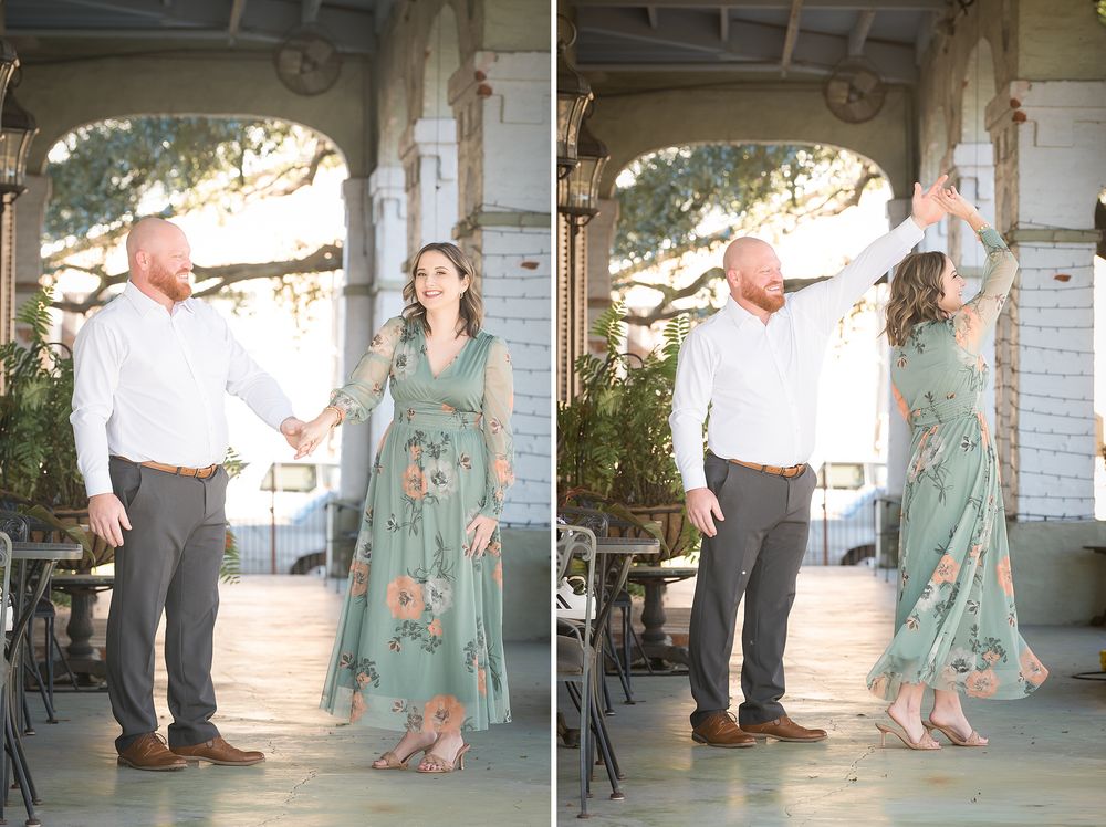 Couple dancing outdoors on a porch, woman in floral green dress being twirled by man in white shirt and gray pants.