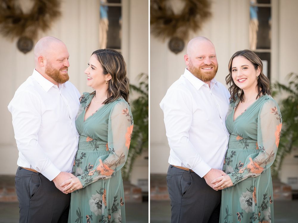 Couple posing outdoors, man in white shirt and woman in green floral dress, smiling warmly during engagement photo session.