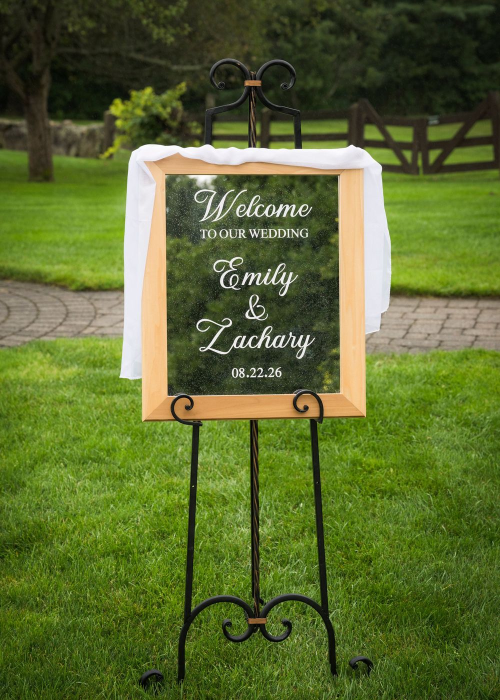 Elegant outdoor wedding welcome sign for Emily and Zachary on August 22, 2026, displayed on a black easel.