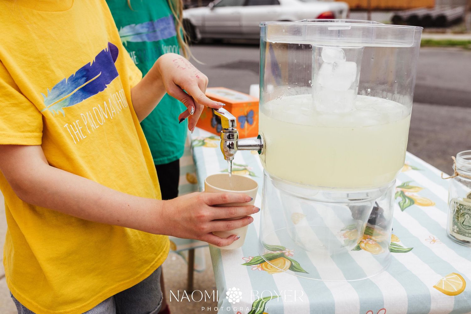 A handwritten sign on a wooden utility pole advertising fresh homemade lemonade on a suburban street.