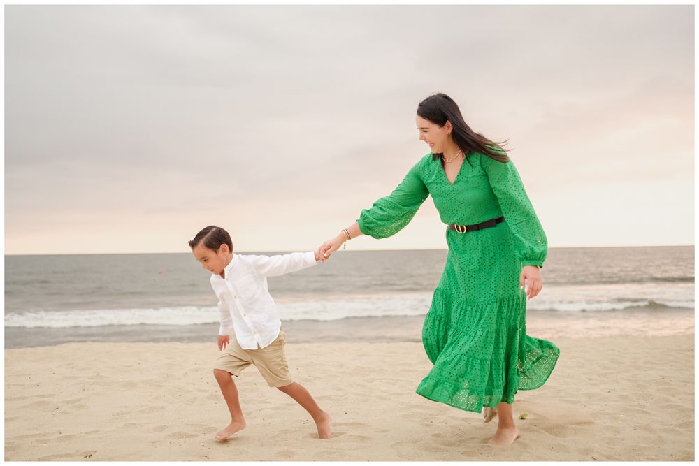 Mother and son dancing on a Punta Mita beach at sunset, candid family photography with golden light in Mexico.