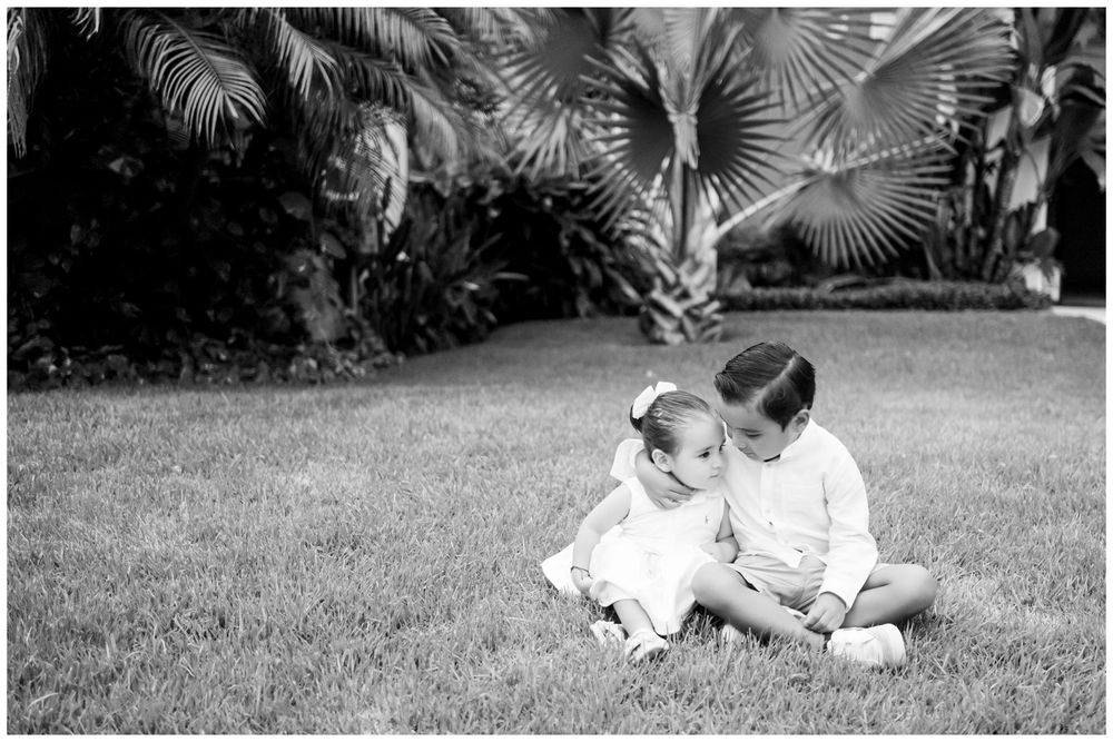 Black and white portrait of siblings in Punta Mita, Mexico with palm trees, candid family photography Riviera Nayarit.