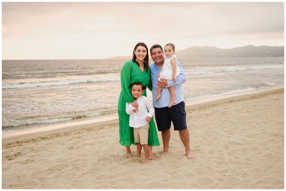 Family of four at sunset on a Punta Mita beach, candid family photography with golden light and ocean views in Mexico.