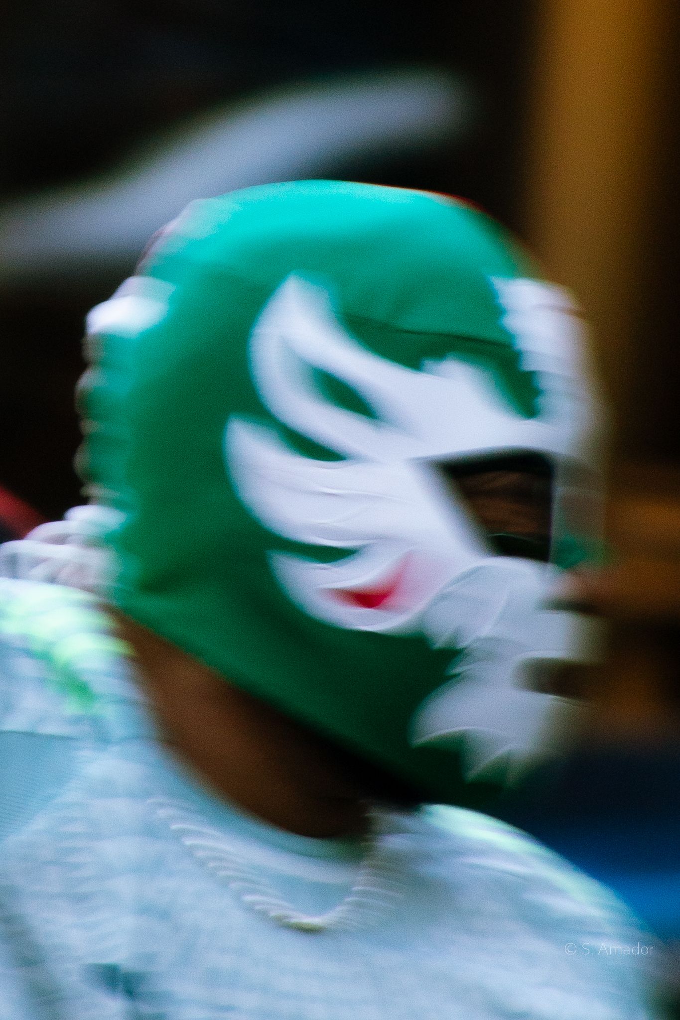 Blurred motion shot of a person wearing a green and white lucha libre wrestling mask during the 2026 World Cup Opener.