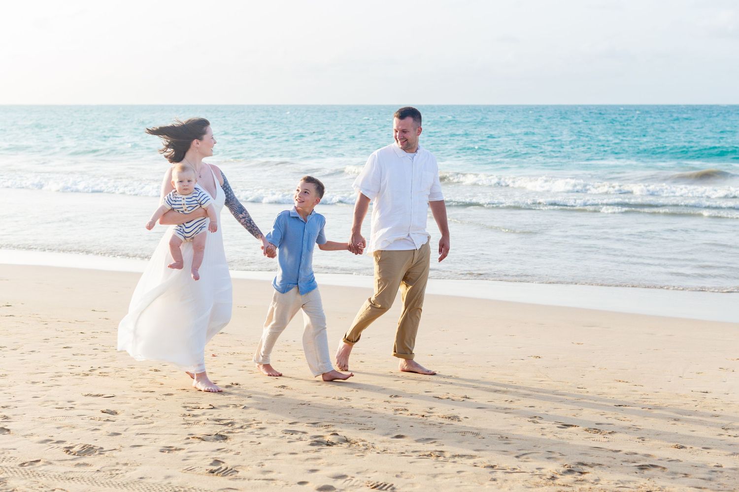 Family portrait walking on the beach in Isla Verde, Carolina, Puerto Rico. Father, mother and two sons.