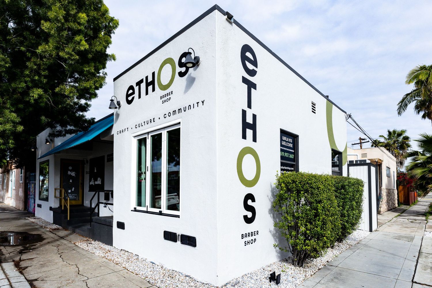 San Diego commercial real estate photography of the modern white exterior of Ethos Barber Shop with custom signage.