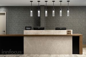 Modern Hilton hotel front desk with a marble counter, wood trim, and six pendant lights hanging against a textured dark gray accent wall.