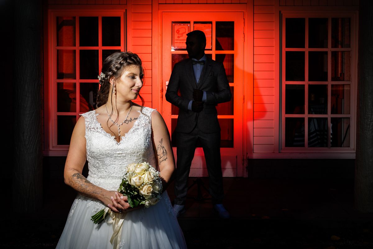 A couple embraces among green vineyard leaves during their wedding day.