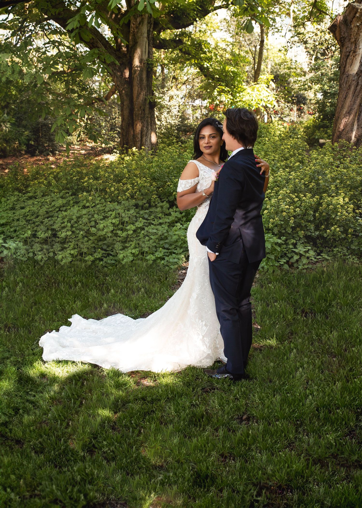 Classic outdoor wedding portrait by London photographer Virginija Photography. Bride and groom posing in a green garden.