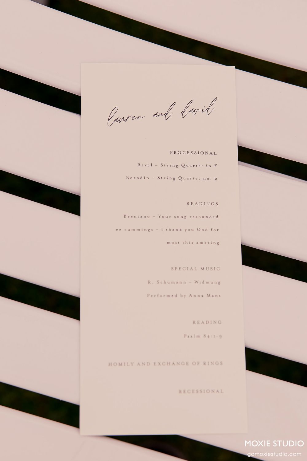 Minimalist wedding program cards with elegant typography and details printed in soft gray on white paper.