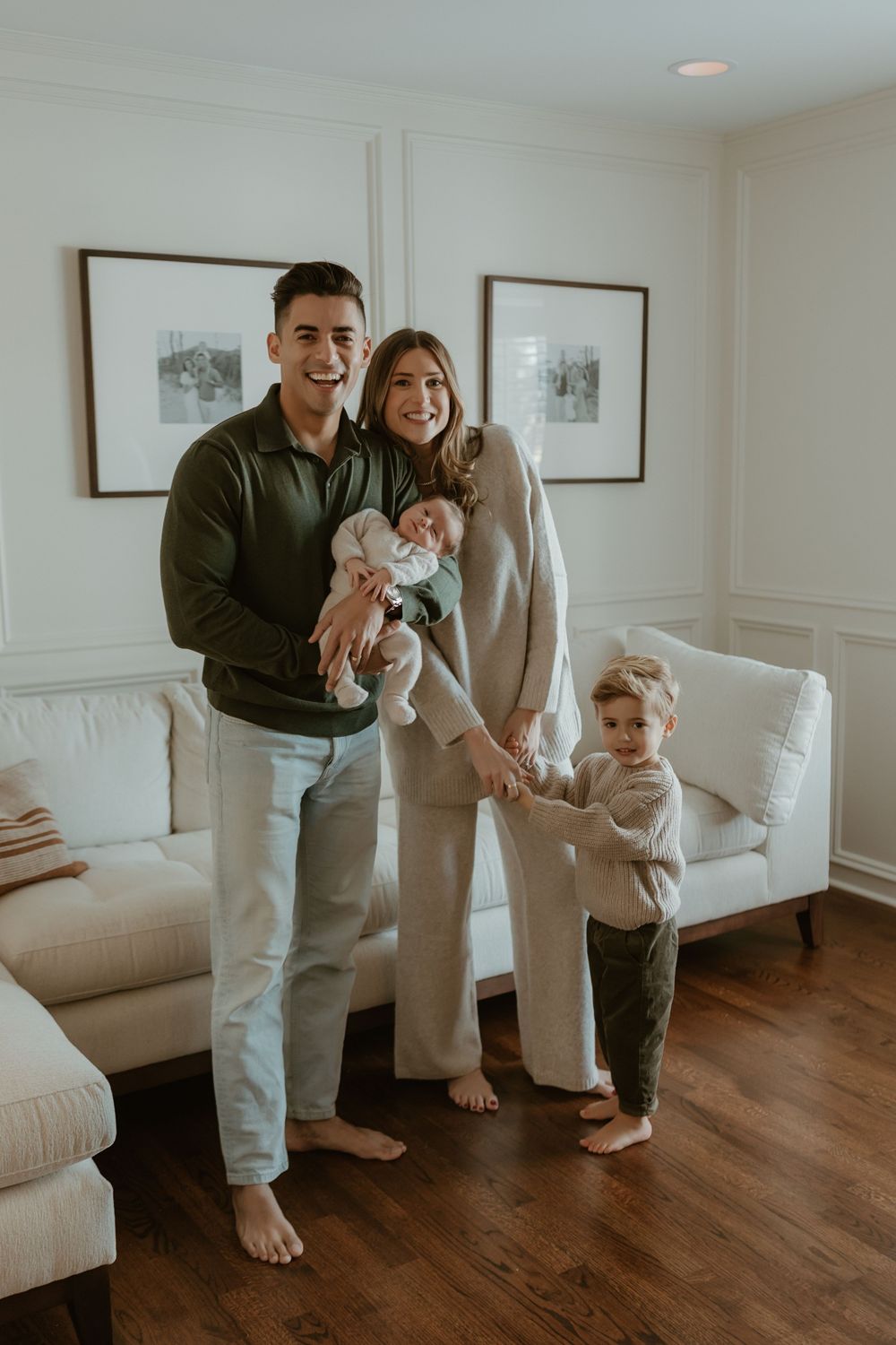 Candid family moments captured in living room with white decor and hardwood floors.