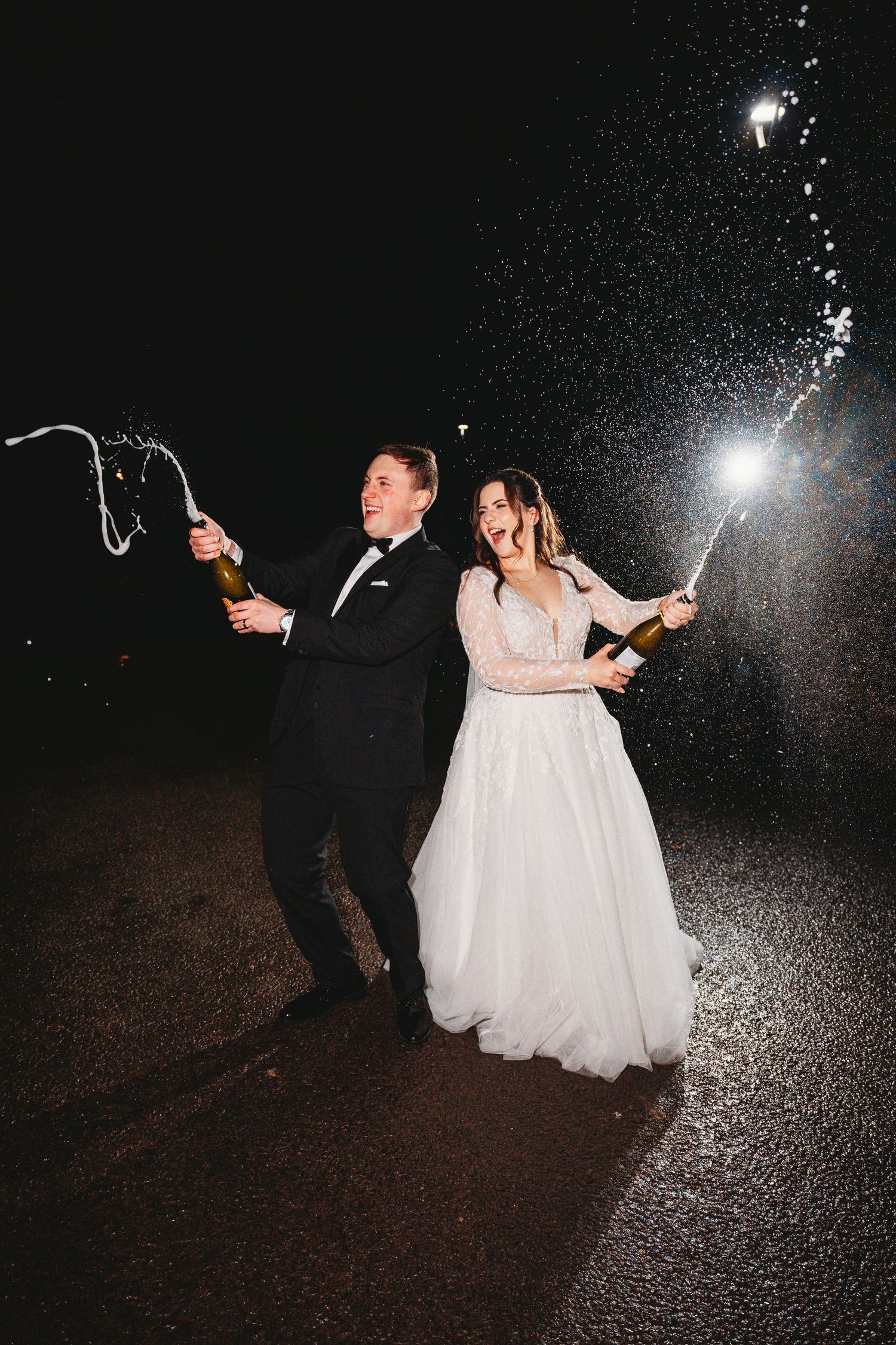 Wedding couple poses dramatically in an archway with red brick columns.