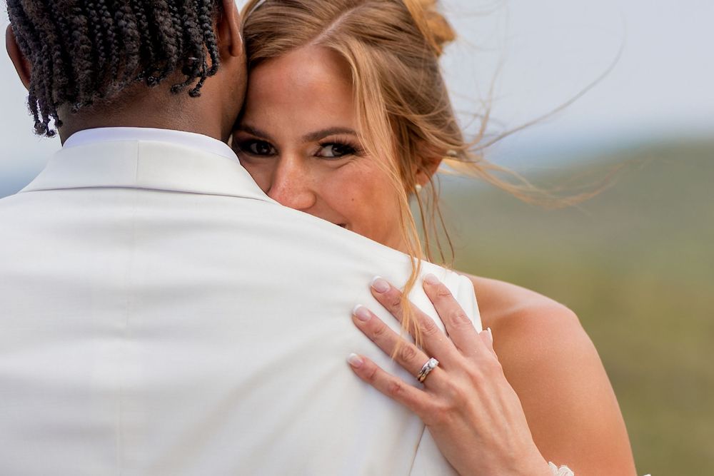 A bride and groom share a romantic embrace while dancing together at their outdoor wedding celebration.