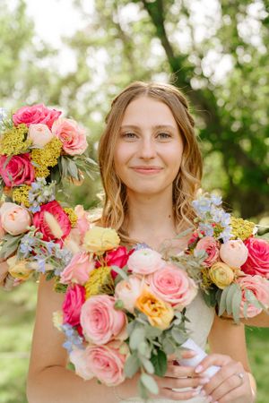 Beautiful floral bouquet featuring pink and coral roses with delicate blue accents.