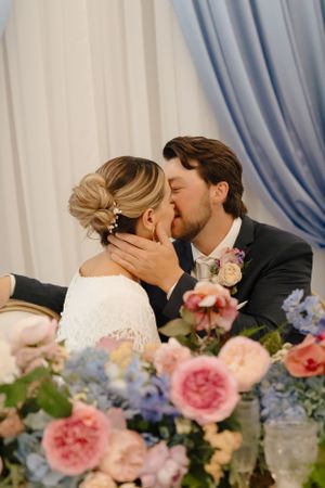 Romantic wedding moment with pink and blue floral decorations.