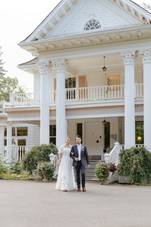 Stately white Southern mansion with grand columns and balcony decorated for a wedding.