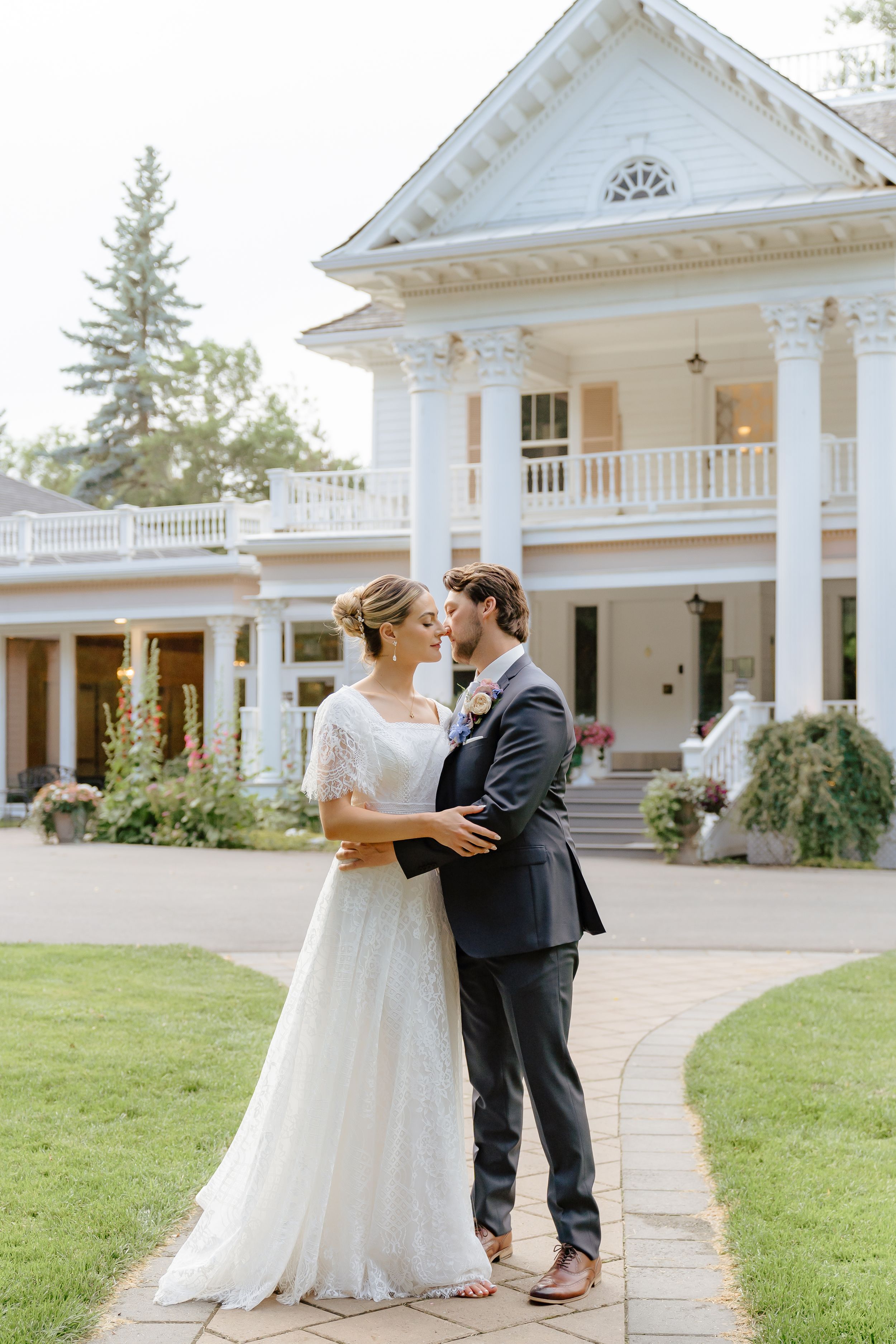 Romantic wedding portrait in front of white mansion with couple on stone pathway. The Norland wedding venue.