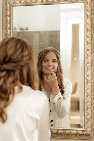 A series of mirror reflections showing someone in a white button-up top with a playful expression.