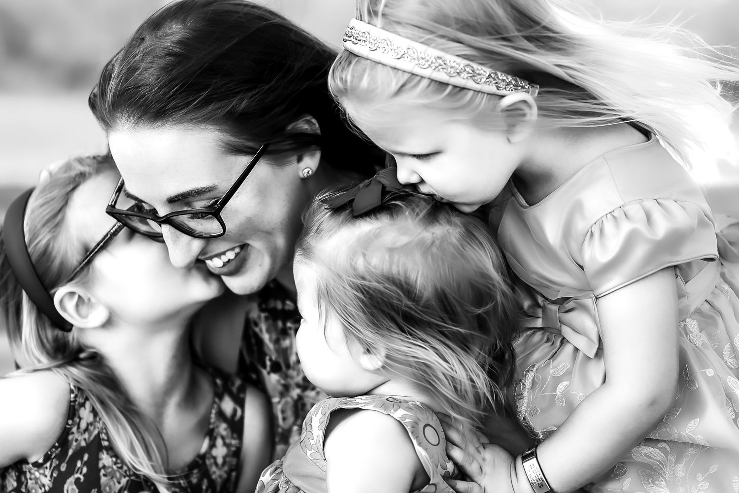 Mother and daughters embrace.