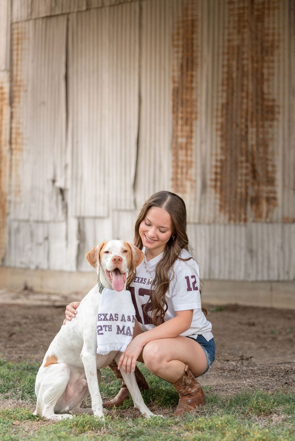 Senior girl with Aggie shirt posing with dog wearing Aggie bandana