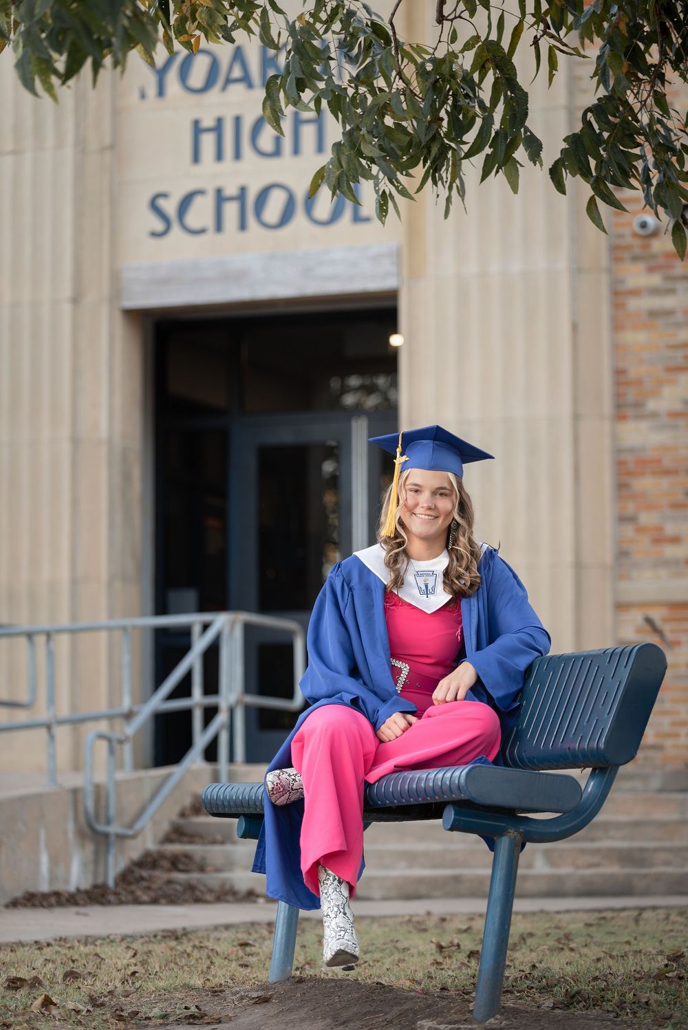 senior girl outside of high school wearing gown.