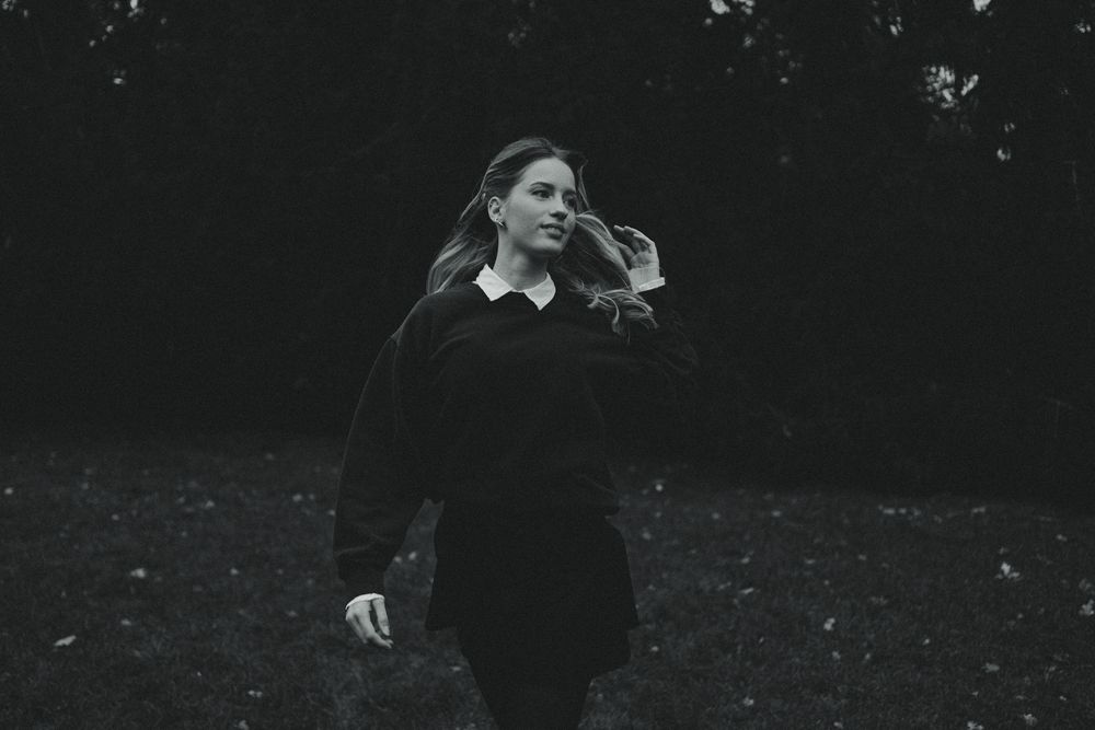 Nostalgisches Fotoshooting zur Blauen Stunde im Großen Garten Dresden - Frau rennt über Wiese und fässt sich durch das Haar