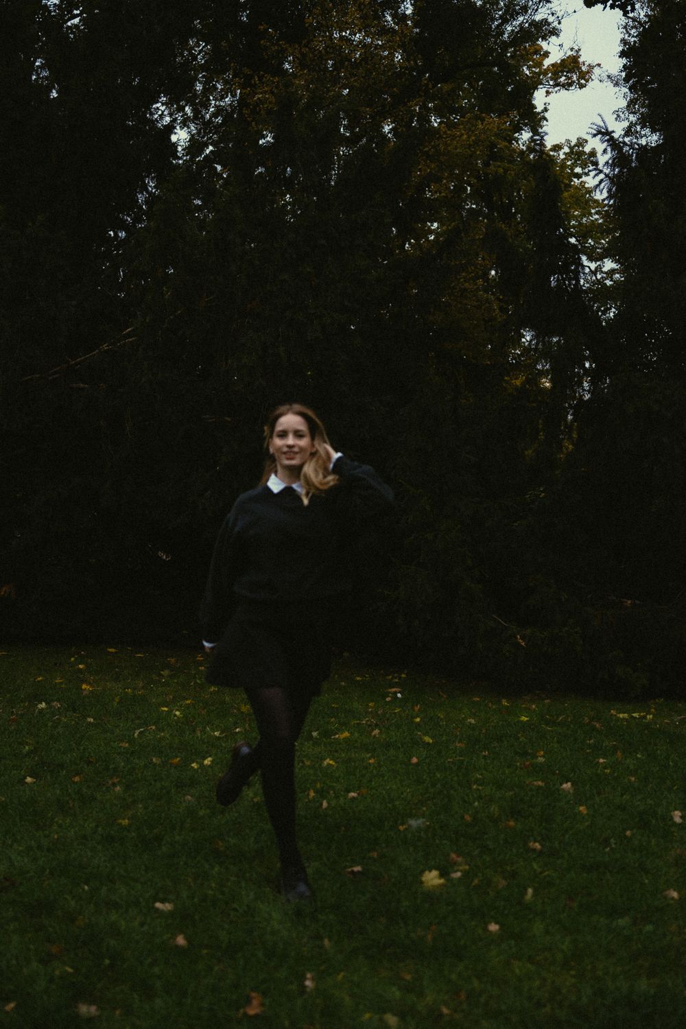 Portrait Fotoshooting Dresden Großer Garten - Frau rennt auf Wiese durch den Park und fässt sich dabei lächelnd durch die Haare