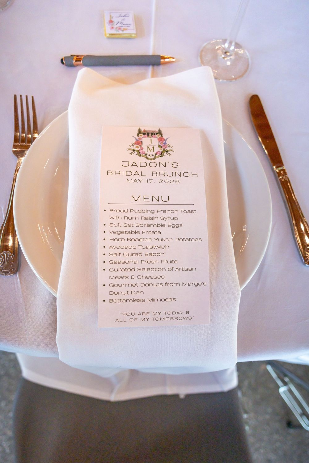 Elegant bridal brunch place setting with personalized menu on white plate for Jadon's Bridal Brunch May 2026.