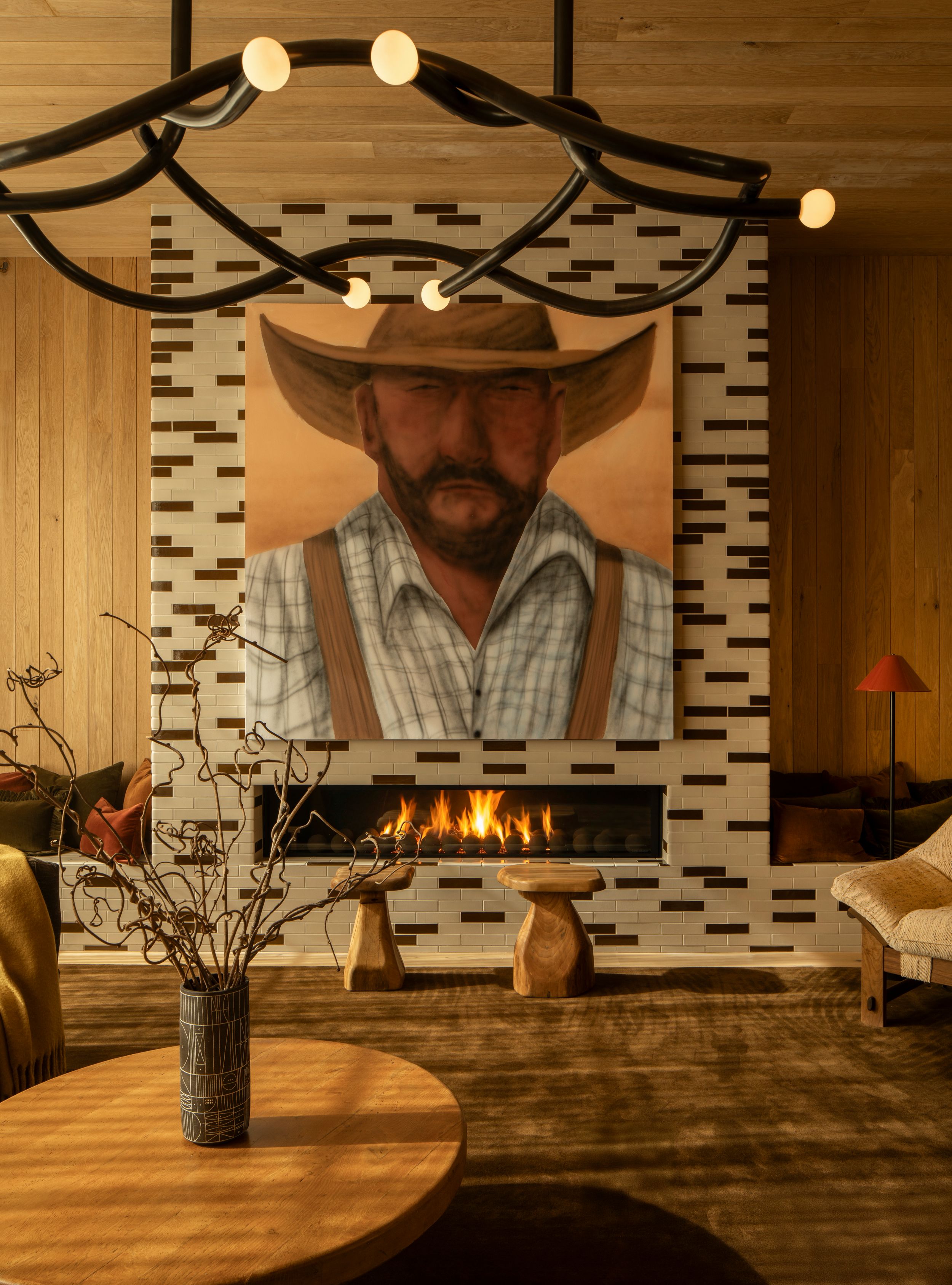 Rustic restaurant interior with wooden tables and ambient lighting showcases modern decor and warm fireplace glow.