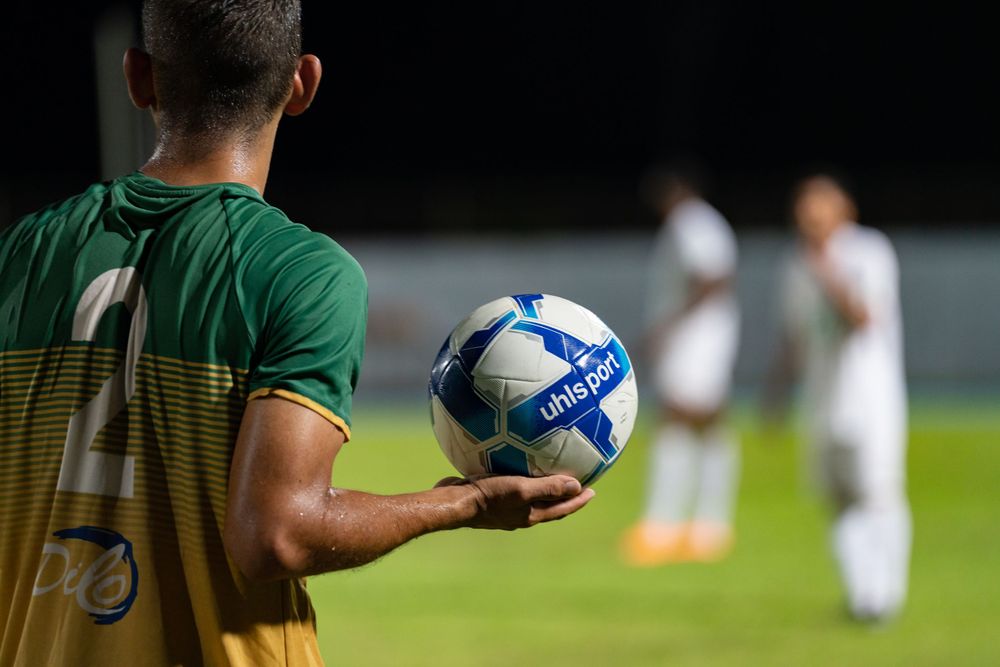 Joueur de football tenant le ballon dans un stade en Guyane