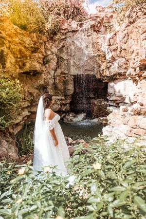 A flowing waterfall cascades down rocky cliffs surrounded by autumn foliage and lush greenery in a scenic natural setting.