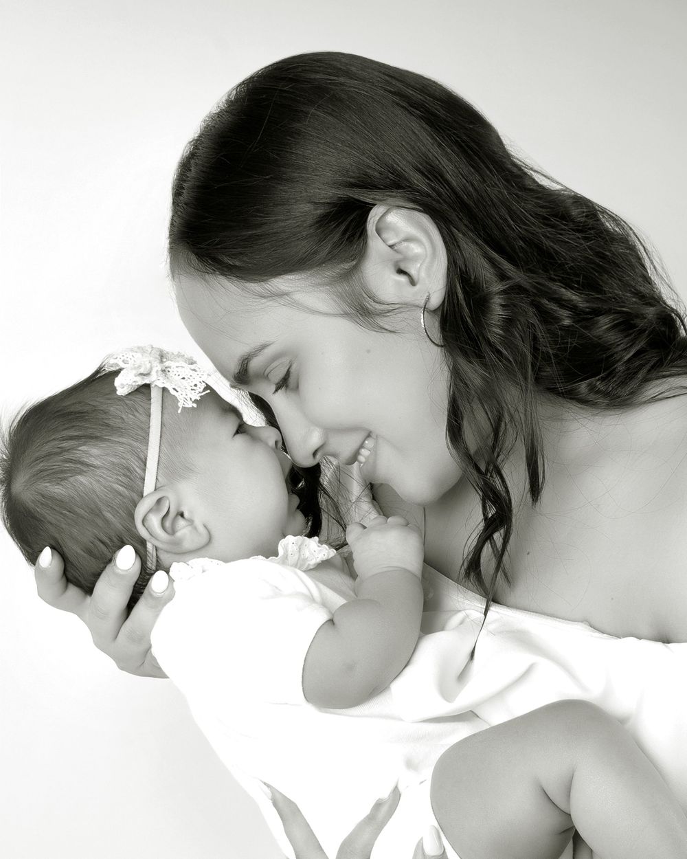 A silhouetted mother and child share an intimate moment in black and white silhouette profile.