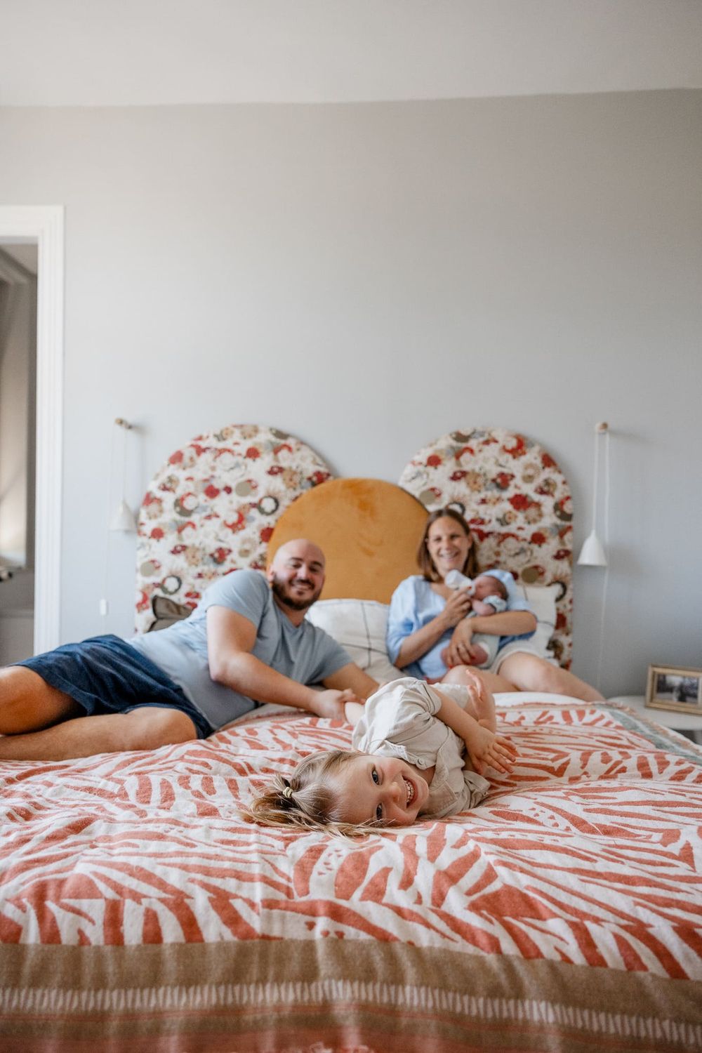 Papa joue avec la grande pendant que maman donne le biberon au bebe pendant une seance photo de famille joyeuse a Croix pres de Lille