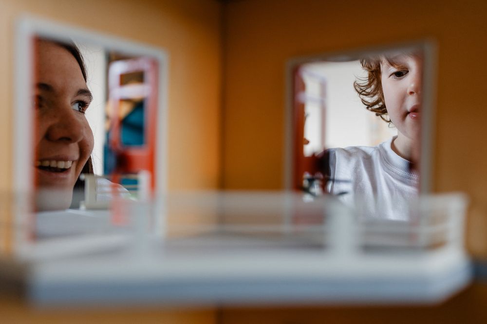 Maman et son fils jouant aux playmobil sous l'objectif d'une photographe famille Lille venant a domicile pour capturer le quotidien simple