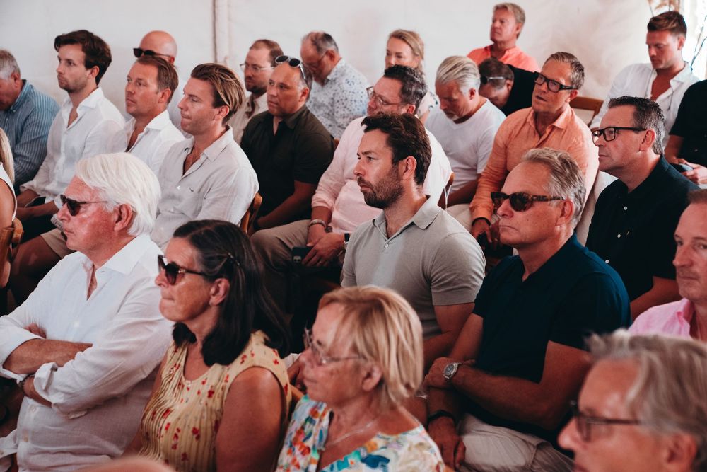 An attentive audience of people sits and watches intently during a presentation or performance.