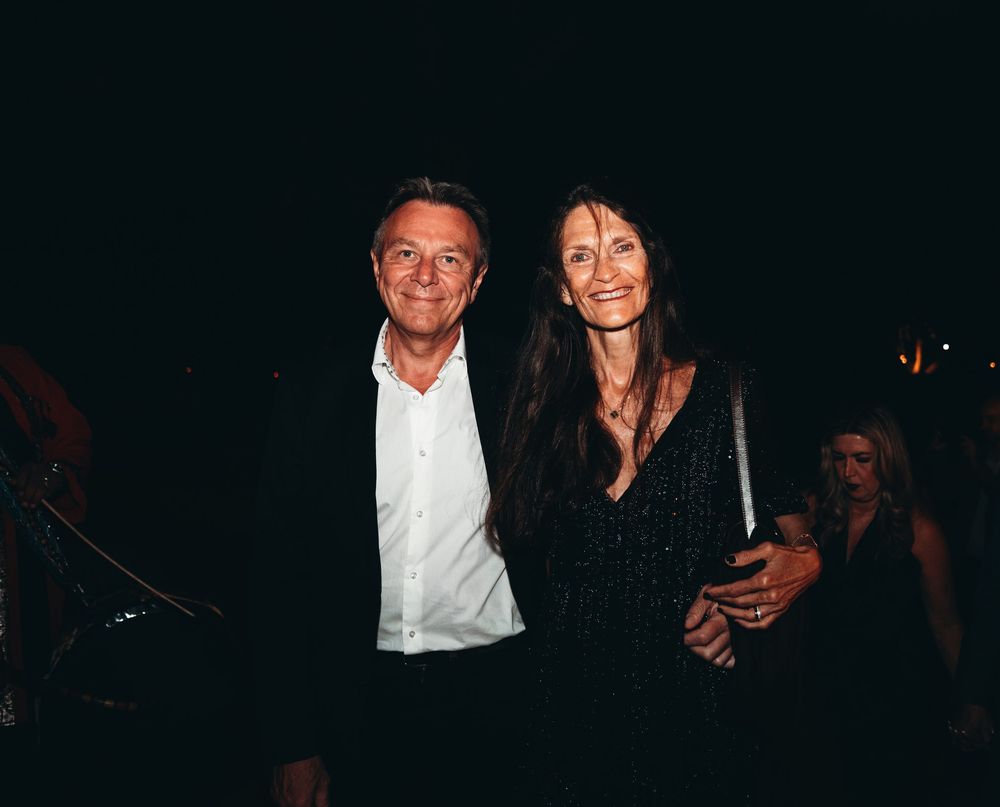 A group of people in dark clothing gathered at a dimly lit event or party setting.