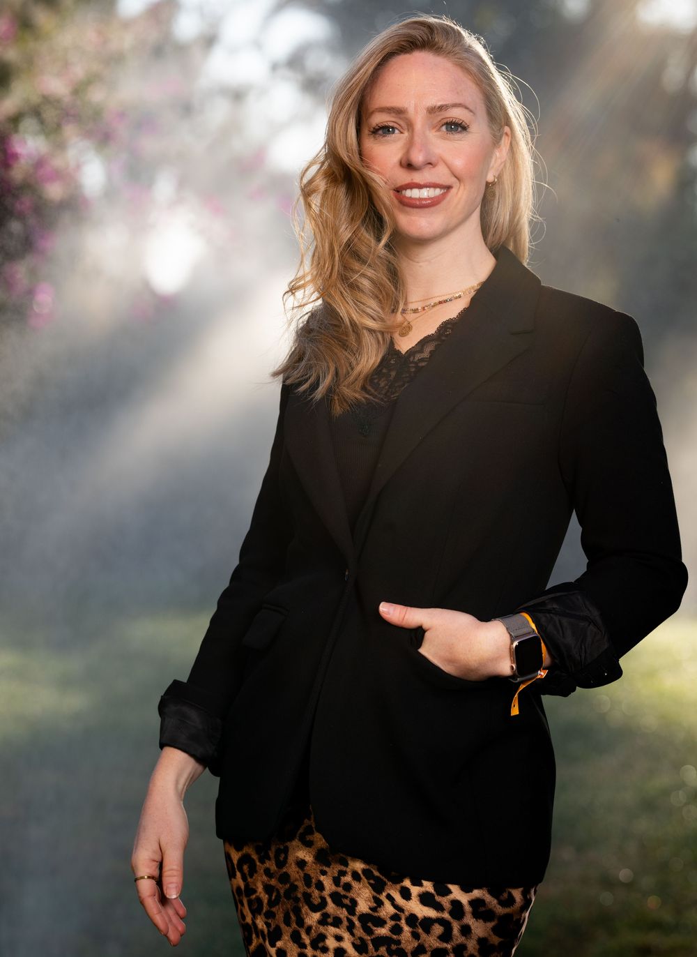 Professional lifestyle portrait of someone wearing a black blouse and leopard print skirt in soft natural lighting.