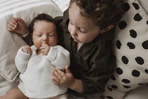 Séance photo naissance à domicile – Un cocon de tendresse avec le grand frère